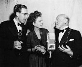 Actor Edmund Gwenn (right) and writer George Seaton (left) holding their Oscars for the film 'Miracle on 34th Street', with presenter Anne Baxter, at the 20th Academy Awards, Los Angeles, March 20th 1948. (Photo by Archive Photos/Getty Images)